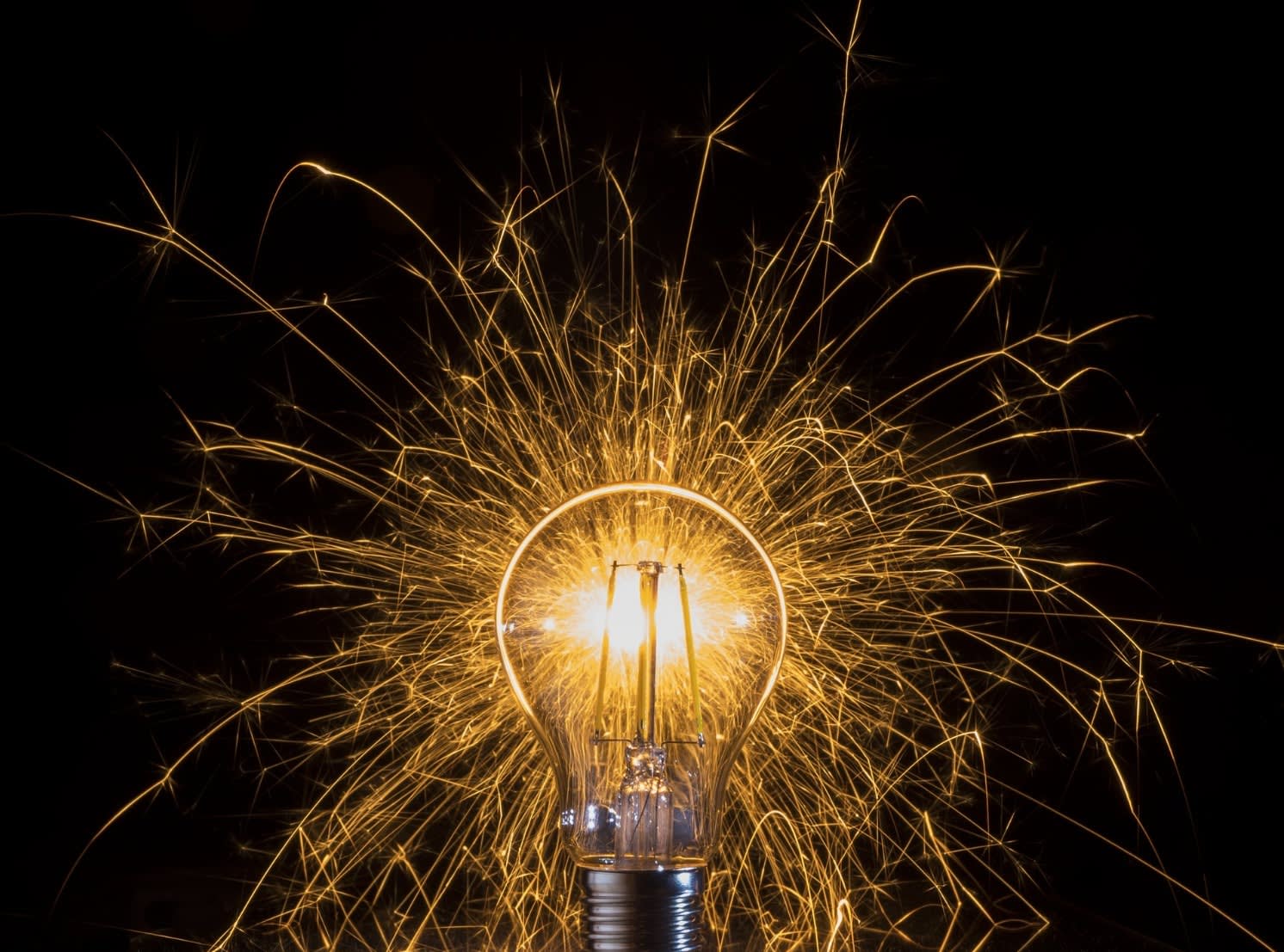 A lightbulb sparking against a black background