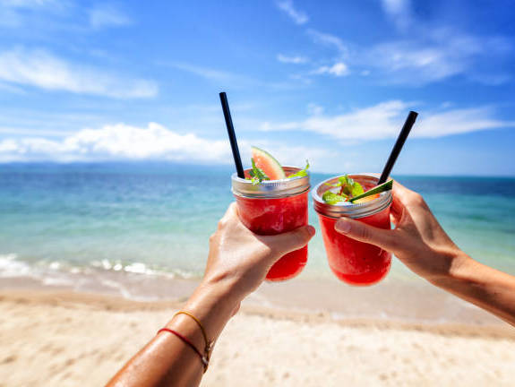 fresh-watermelon-juice-in-two-glasses-against-a-bright-tropical-landscape-background-of-the