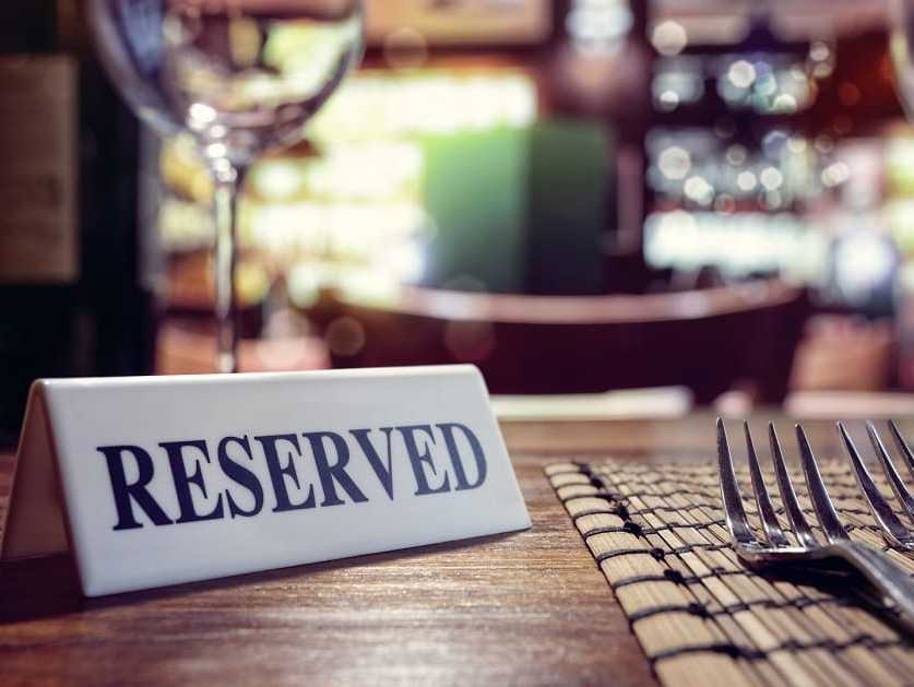 Sign that reads "reserved" sitting on a set table