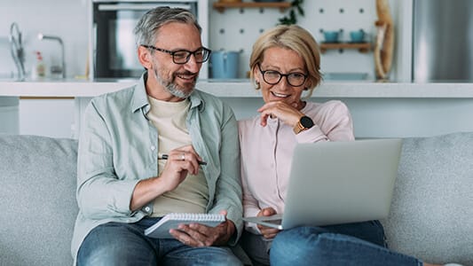 Mature couple managing budget and paying bills and taxes. Shot of a lovely mature couple reviewing their finances while using laptop.