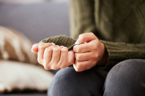 shot-of-a-unrecognizable-woman-sitting-on-a-sofa-and-feeling-anxious