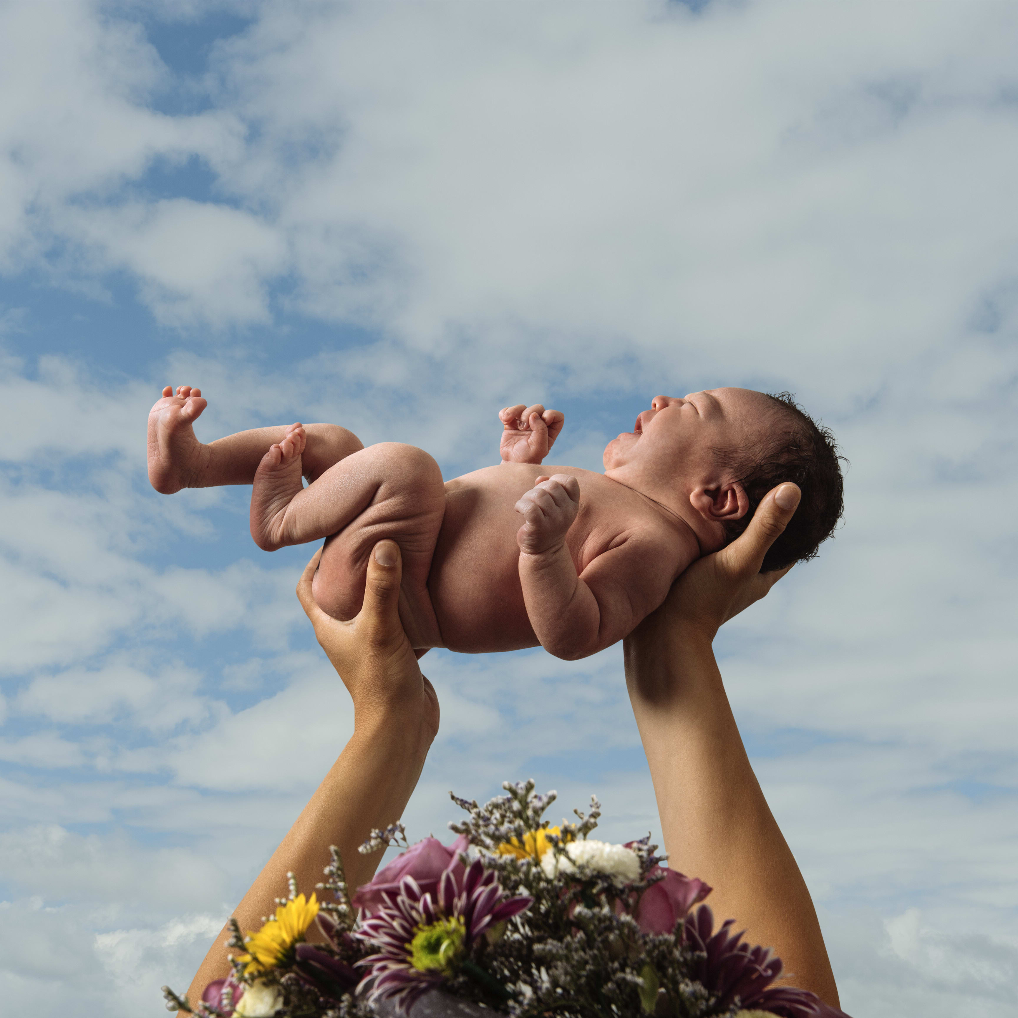 mother-with-flowers-in-hair-holding-baby-boy-in-a-2025-04-03-21-31-51-utc