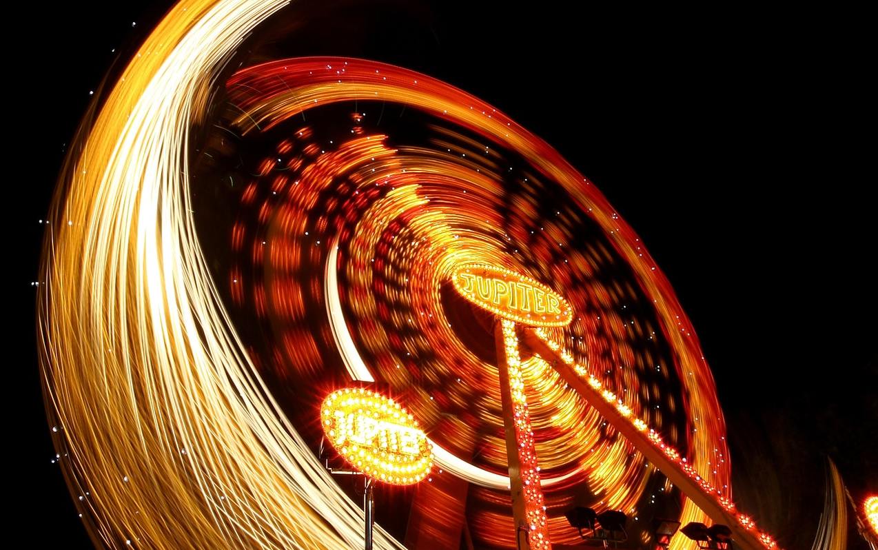 A long exposure of a ferris wheel at night with light trails
