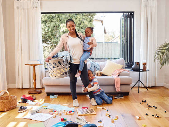 shot-of-a-little-boy-throwing-a-tantrum-while-holding-his-mothers-leg-at-home