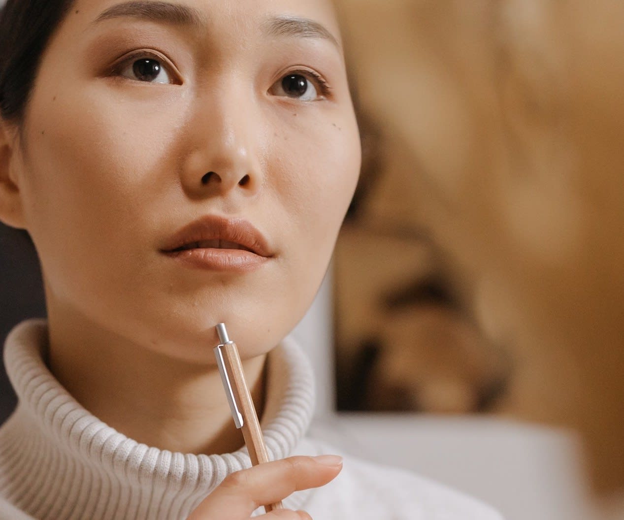 An Asian woman looks thoughtfully into the distance