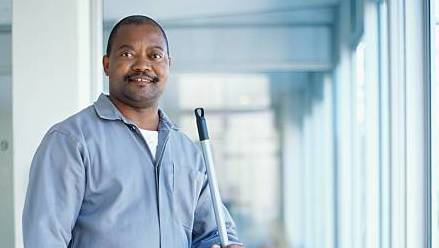 portrait-of-a-cleaner-holding-a-mop-in-an-office