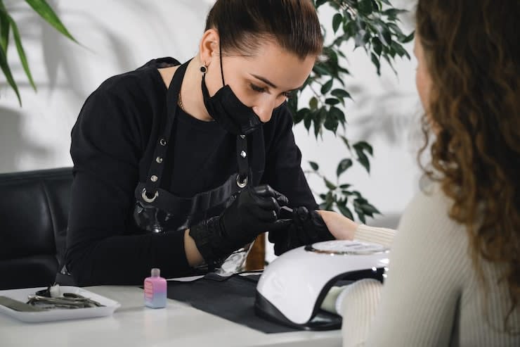 manicure-salon-professional-manicurist-wearing-protective-mask-doing-procedure-woman-modern_1048944-10424182