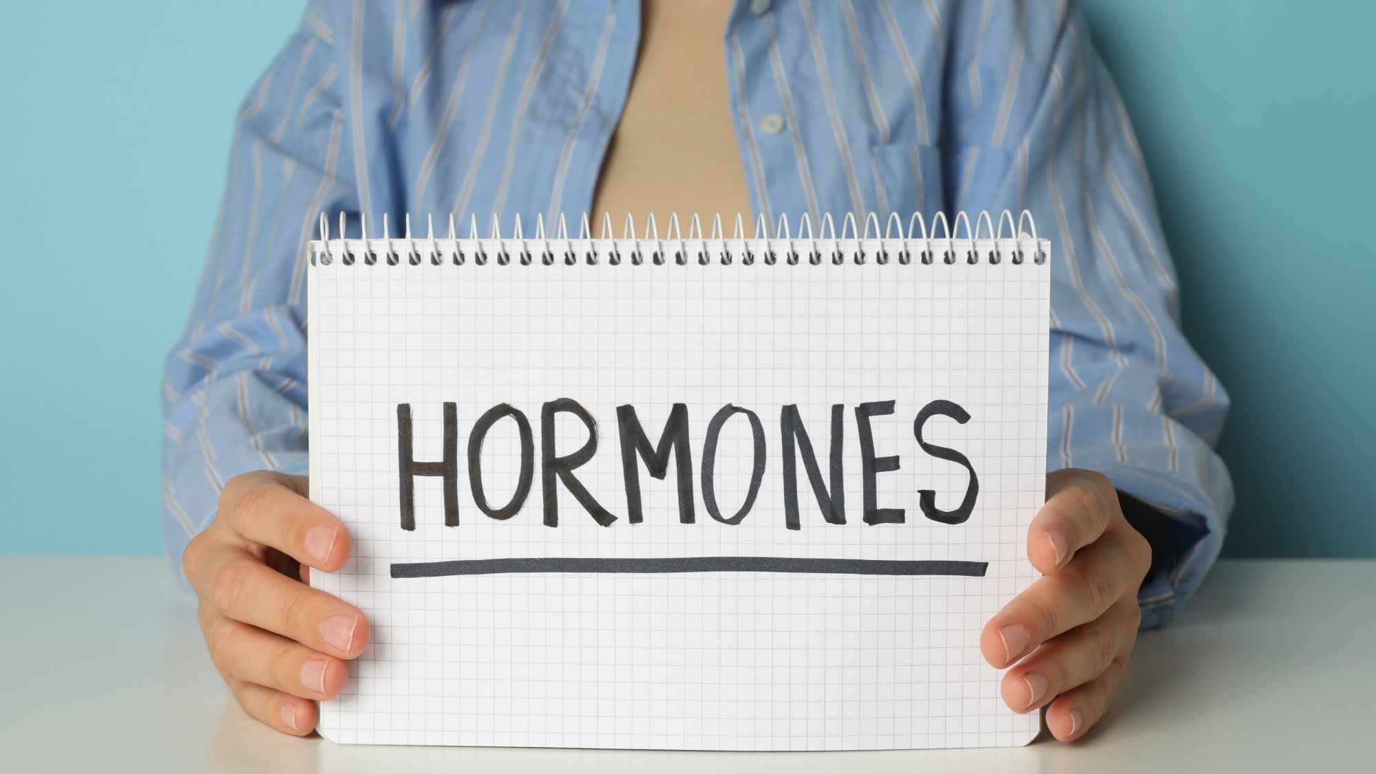 the-word-hormones-in-human-hands-on-a-light-backg-2025-03-25-14-28-50-utc
