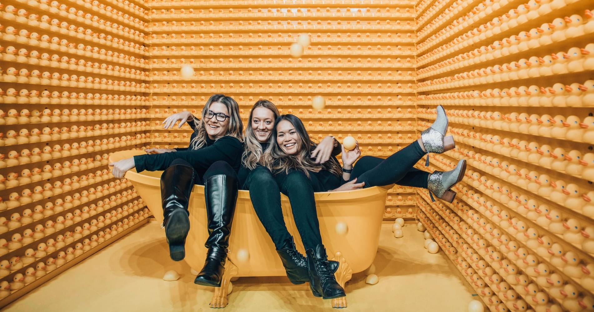 girls sitting in a bathtub with clothing