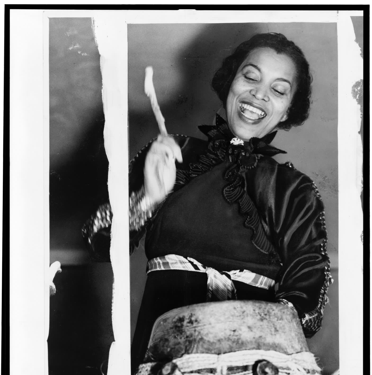 View of American Zora Neale Hurston (1891 - 1960) as she plays the hountar (or mama drum), New York, 1937. 