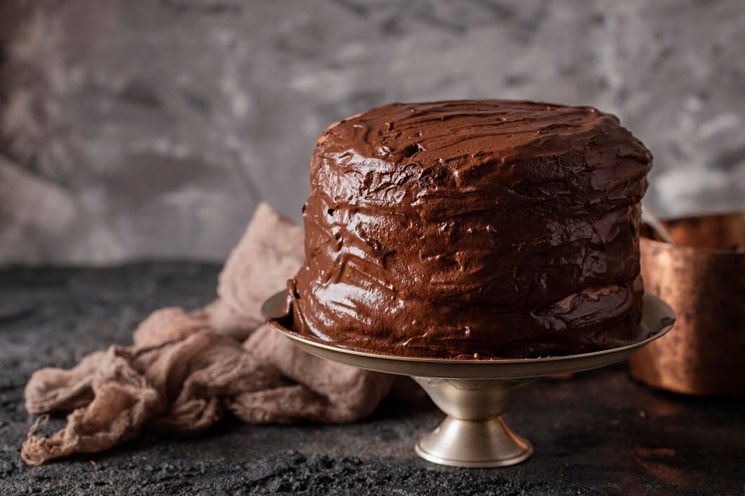 An chocolate-iced cake on a cake stand.