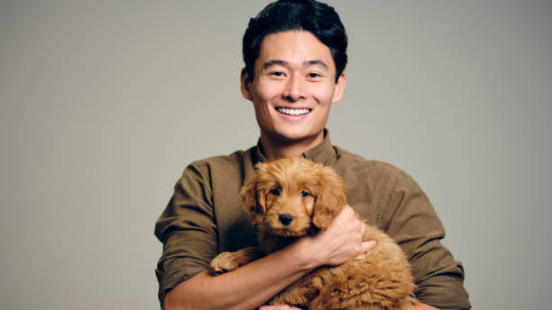 portrait-of-an-asian-man-holding-a-young-dog