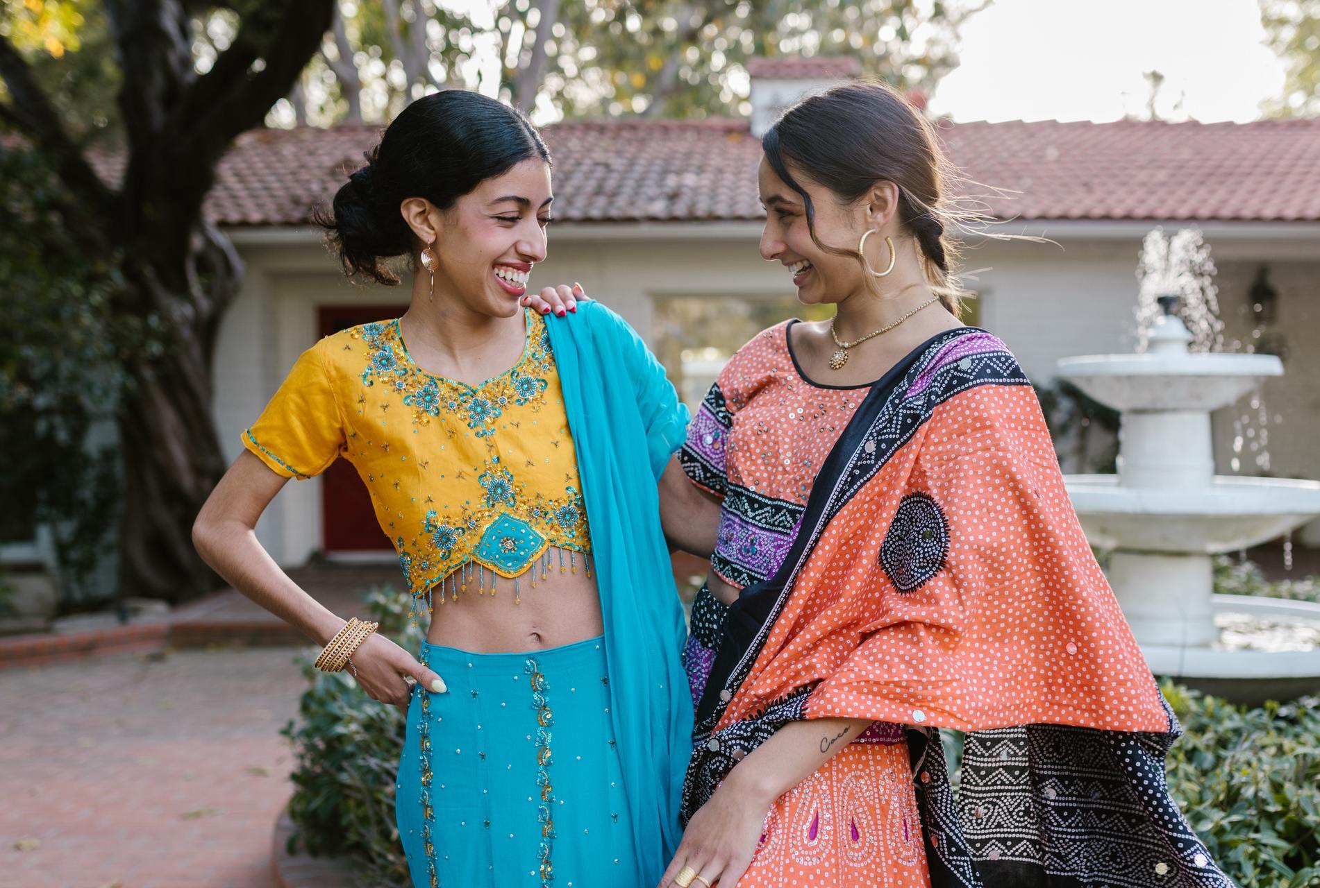 Two South Asian girls in colourful saris laughing together