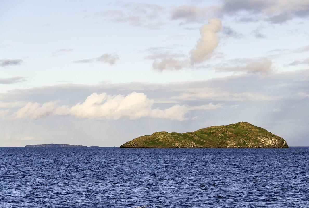 A distant view across choppy waters of a small island