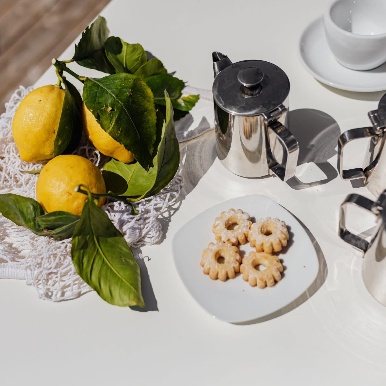 kaboompics_cups-silver-jugs-with-coffee-italian-cookies-and-lemons-on-the-table-12940