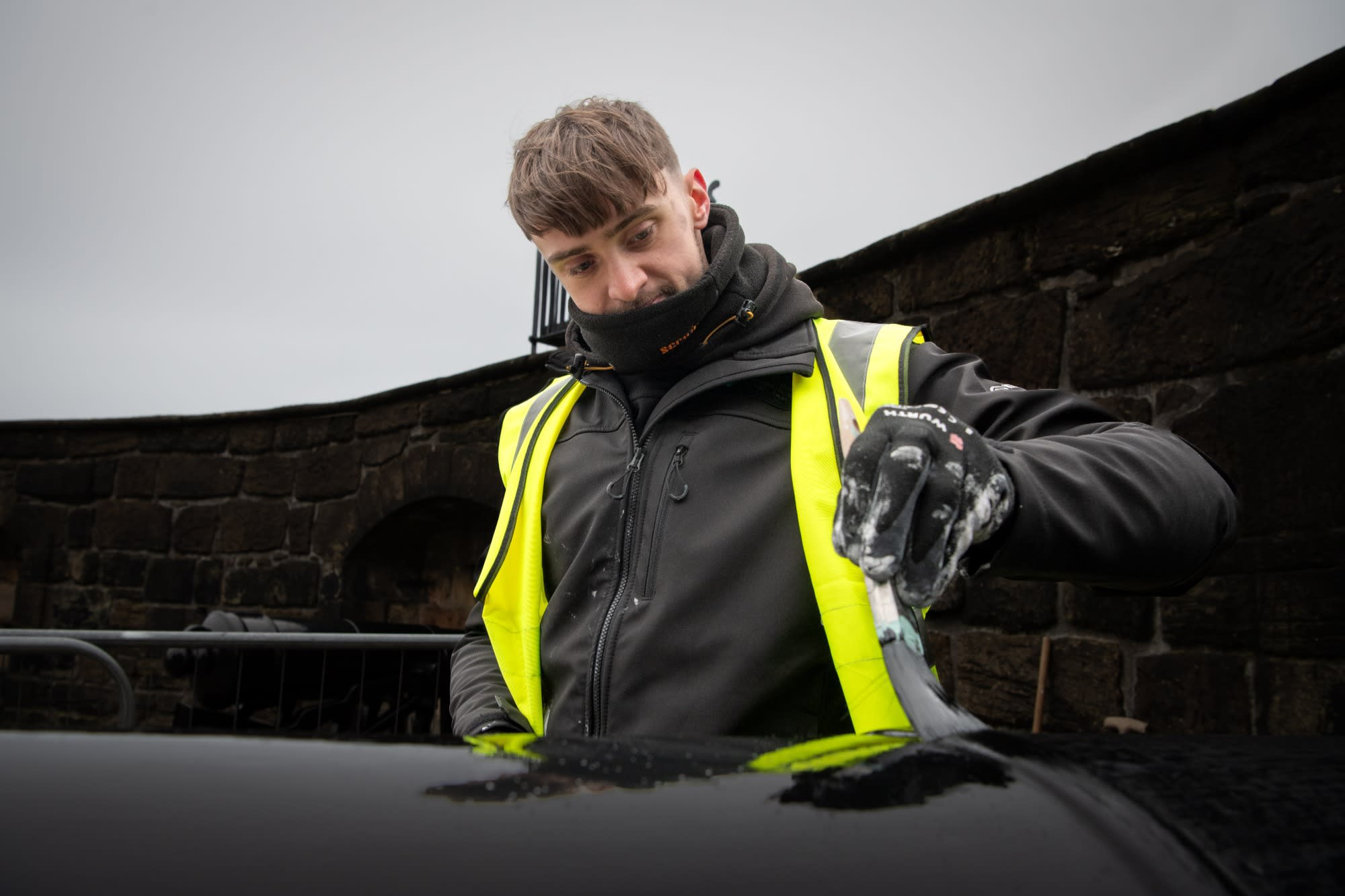 A man wearing a high vis jacket and painting a cannon