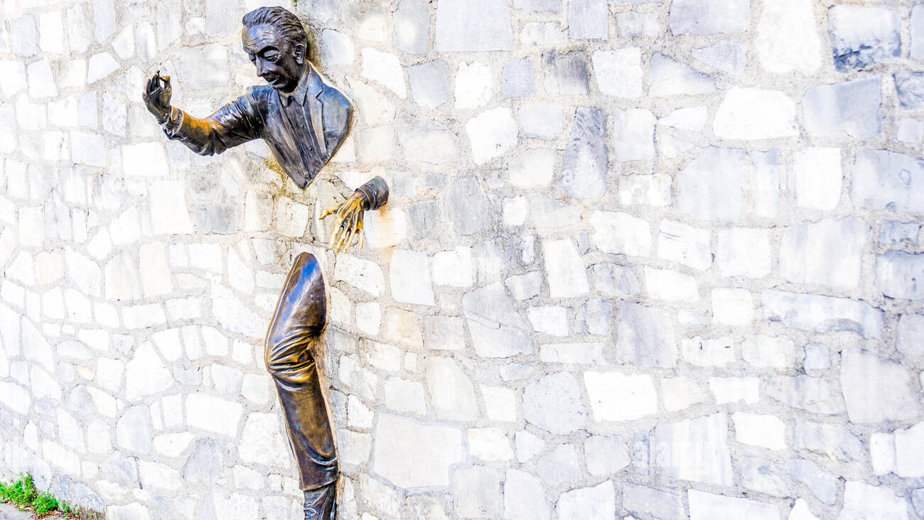 the-passe-muraille-stucked-into-the-wall-of-the-marcel-aym-place-is-KD1ADN