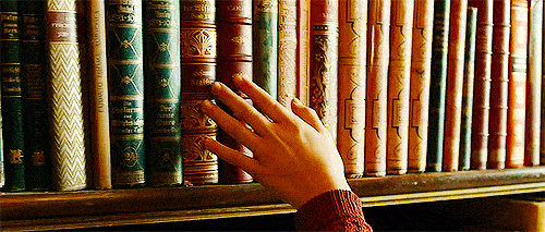 Person is running hands across the books in a gif. 