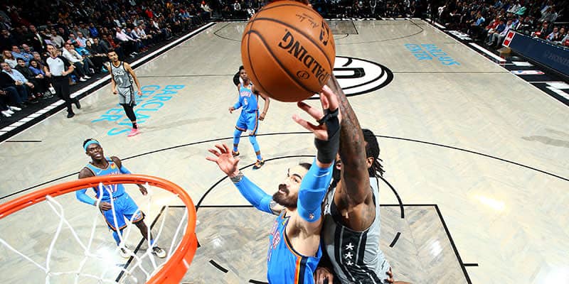 Basketball player reaches for the net