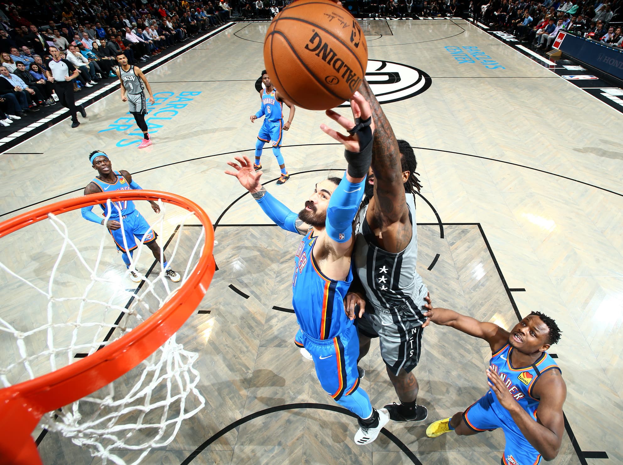 Basketball player reaches for the net